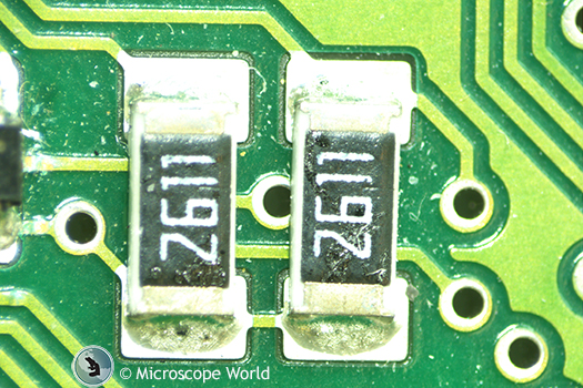 Circuit board under stereo microscope with LED ring light.